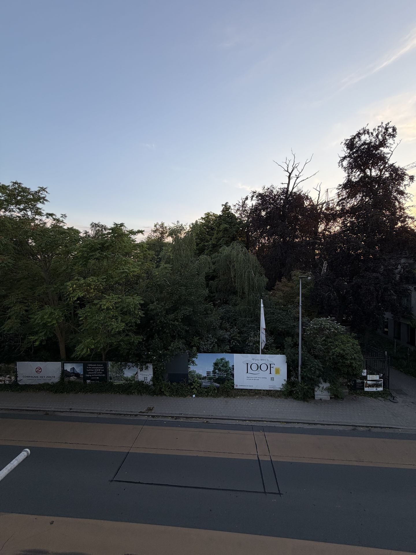 Zicht vanaf de straat op de groene toegang tot Park Loof